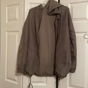 Olive green light weight jacket with a rose near the right shoulder